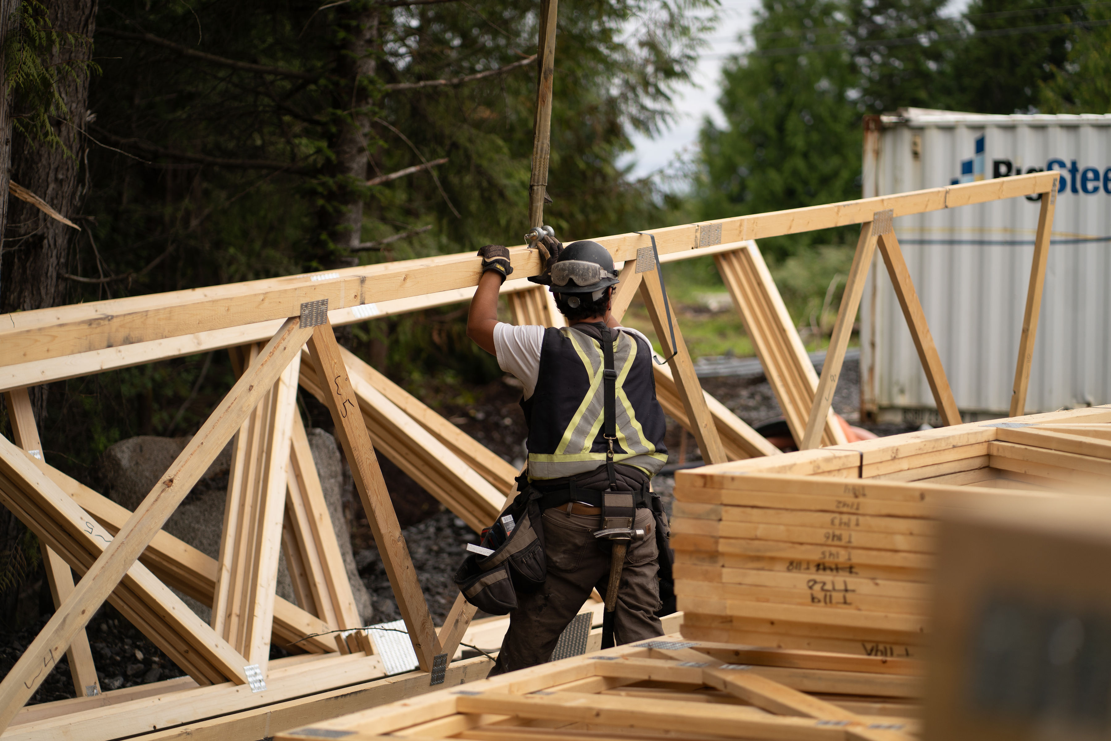 Carpenter working beside timber roof trusses